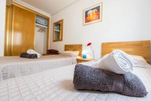 a bedroom with two beds with a pillow on it at Oriheula Costa Cabo Roig 5 in Playas de Orihuela +29 photos
