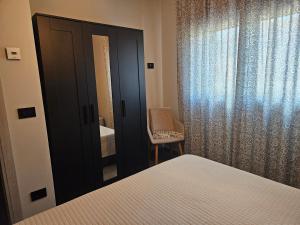 a bedroom with a mirror and a bed and a chair at EdenGHouse in Cordenons
