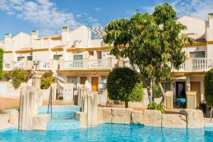 a hotel with a swimming pool in front of a building at Oriheula Costa Cabo Roig 5 in Playas de Orihuela