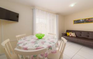 a dining room with a table and a couch at Residencial Dona Naime in Bombinhas
