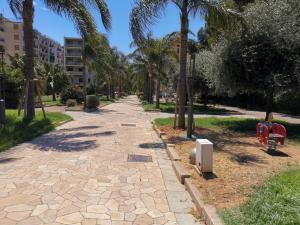 a path in a park with palm trees at Hotel Europa in Arma di Taggia