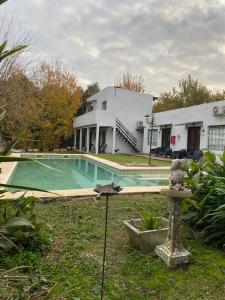 a house with a swimming pool in the yard at Posada Tordillo Hosteria Rural in Chascomús