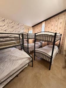 three bunk beds in a room with a wall at M&W Hostel in Yerevan