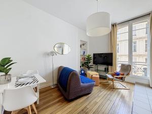 a white living room with a table and a chair at Le Cours Langlet B in Reims