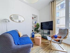 a living room with a couch and a tv at Le Cours Langlet B in Reims