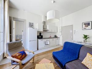 a living room with a couch and a kitchen at Le Cours Langlet B in Reims