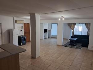 a kitchen and living room with a couch and a table at Charles Guest House in Germiston