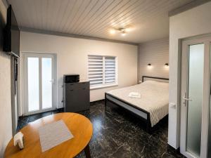 a small bedroom with a bed and a table at Апарт Стефанія in Skhidnitsa +32 photos