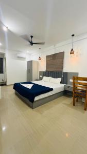 a bedroom with a large bed and a chair at Lowfare Hotels Bengaluru in Bangalore