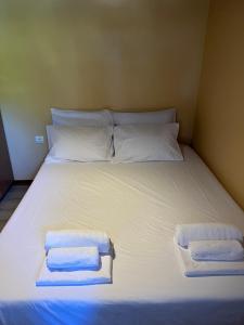 a bed with white sheets and two towels on it at Amarynthos Tiny Retreat in Amarynthos