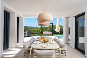 a dining room with a white table and chairs at Villa Loparia in Lopar