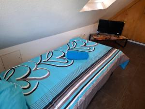 a bedroom with a bed with a blue comforter at GR ooms Rents in Gemmrigheim