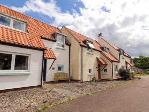 a row of houses with a bench in the street at Sarah's Cottage in Berwick-Upon-Tweed