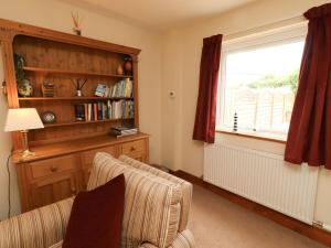 a living room with a couch and a window at Sarah's Cottage in Berwick-Upon-Tweed