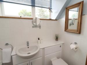 a white bathroom with a sink and a mirror at Sarah's Cottage in Berwick-Upon-Tweed +23 photos