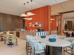 a restaurant with tables and chairs and a counter at SO Ras Al Khaimah Hotel & Resort-Ultra All Inclusive in Ras al Khaimah