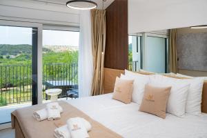 a bedroom with a white bed with a balcony at Villa Loparia in Lopar +81 photos
