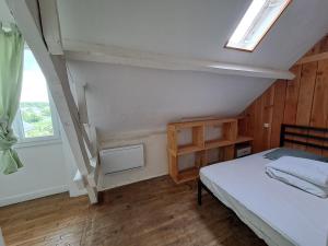 a small bedroom with a bed and a window at Les Hellébores in Égletons