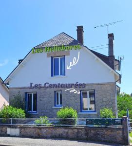 a building with a sign on the side of it at Les Hellébores in Égletons