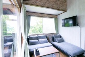 a living room with a couch and a window at コテージひだまり in Izunokuni