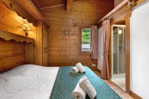a bedroom with a bed in a wooden cabin at Appartement Airelles B25 in Levassaix