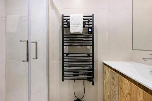 a bathroom with a towel rack next to a shower at Appartement Le Panorama Des Pistes in Les Menuires +17 photos