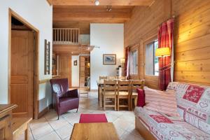 a living room with a couch and a table at Appartement Airelles B25 in Levassaix
