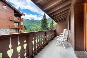 a balcony with a chair and a view of the mountains at Appartement Airelles B25 in Levassaix