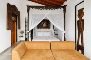 a bedroom with a canopy bed with a couch at Waterland in Negombo +62 photos