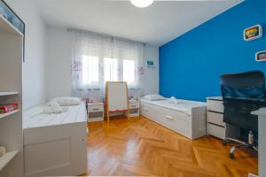 a bedroom with two beds and a blue wall at Apartment Niksa in Pula