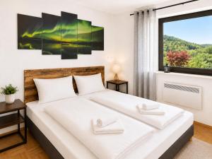a bedroom with a large white bed and a window at Ferienwohnung Seeblick 24 in Winterberg