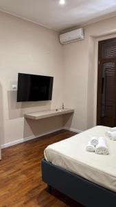 a bedroom with a bed and a flat screen tv at Helios Home in Reggio di Calabria