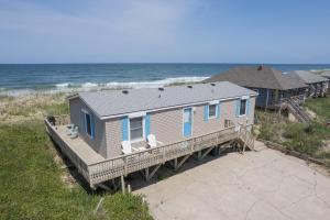 a house on a dock next to the ocean at 5010 - Once Upon A Tide in Kill Devil Hills