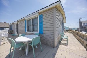 a patio with a table and chairs on a deck at 5010 - Once Upon A Tide in Kill Devil Hills