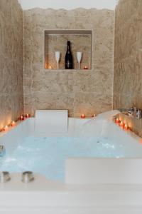a bath tub with candles and a bottle of wine at Suite Katalanos & Spa in Le Barcarès +32 photos