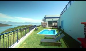 ein Balkon eines Hauses mit Swimmingpool in der Unterkunft Gefen vila in Skroponeria