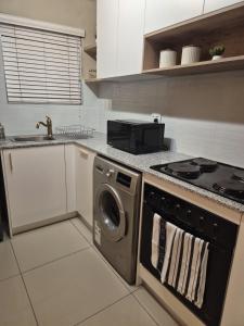 a kitchen with a stove and a washing machine at Fortune Lux - Tygerwaterfront in Tyger Valley +8 photos