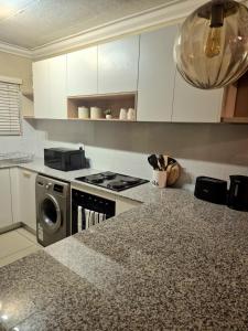 a kitchen with a stove and a washing machine at Fortune Lux - Tygerwaterfront in Tyger Valley