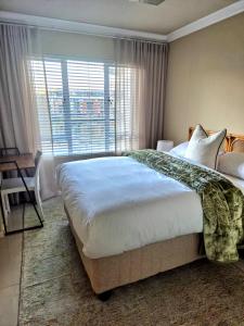 a bedroom with a large bed and a window at Fortune Lux - Tygerwaterfront in Tyger Valley