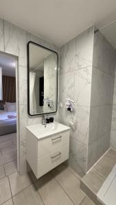 a bathroom with a sink and a mirror at Kimi Résidence in Cannes +91 photos