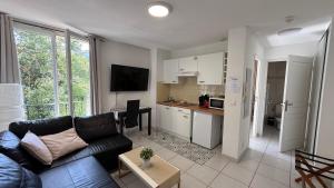 a living room with a couch and a kitchen at Kimi Résidence in Cannes