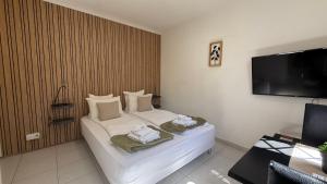 a hotel room with a bed and a flat screen tv at Kimi Résidence in Cannes