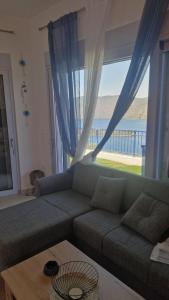 ein Wohnzimmer mit Sofa und großem Fenster in der Unterkunft Gefen vila in Skroponeria
