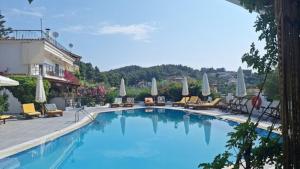 a large blue swimming pool with chairs and umbrellas at Pool me up 22 apartment in Megali Ammos