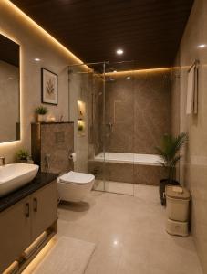 a bathroom with a toilet sink and a shower at Atlantiis Suites Inn By Signature Stays Near Vishwanath Temple Rathyatra in Kakarmatha