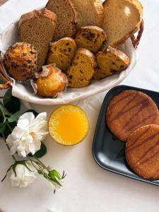 a plate of bread and a plate of muffins and flowers at Vestigia Nueva Castilla in Sigüenza