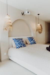 a bedroom with a large bed with blue and white pillows at Suite Katalanos & Spa in Le Barcarès