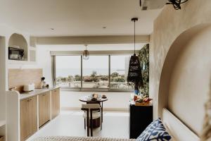 a kitchen and living room with a table in front of a window at Suite Katalanos & Spa in Le Barcarès