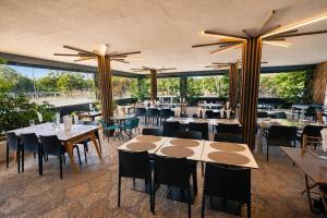a restaurant with tables and chairs and large windows at Kampaoh Lisboa in Lisbon