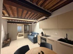 a kitchen and a living room with a blue couch at b&b K2R in Chiusdino